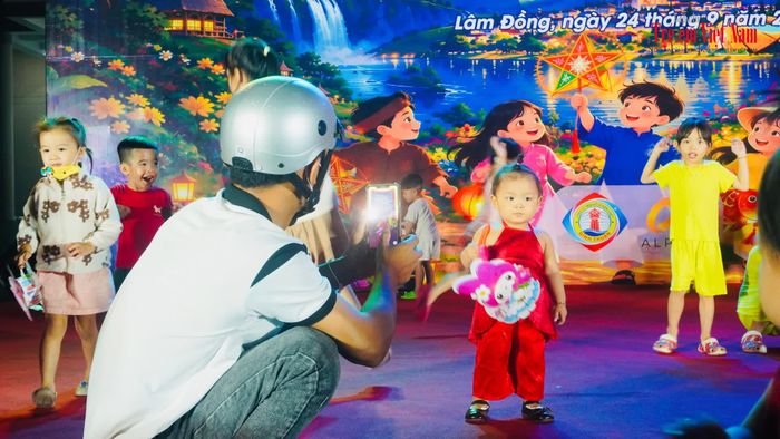 Một ông bố trẻ chụp ảnh cho con gái tại lễ hội Trung thu - (ảnh Ngọc Minh)