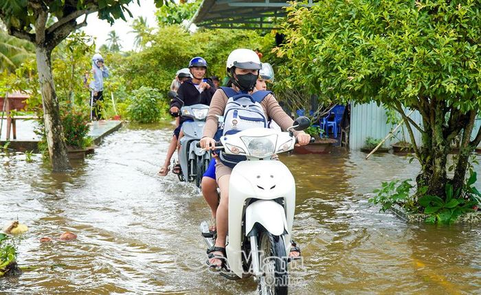 Ngập sâu khiến việc đưa, đón học sinh vất vả.