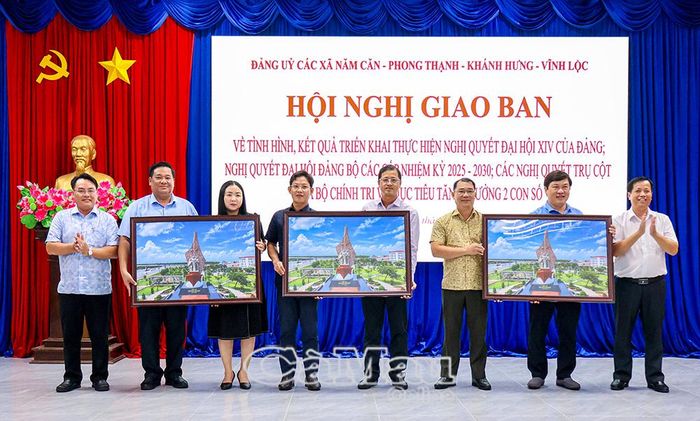  Đồng chí Huỳnh Minh Kiên, Bí thư Đảng uỷ, Chủ tịch HĐND xã Năm Căn (bìa phải) và đồng chí Võ Văn Hành, Phó Bí thư Đảng uỷ, Chủ tịch UBND xã, trao quà lưu niệm cho 3 xã trong cụm.