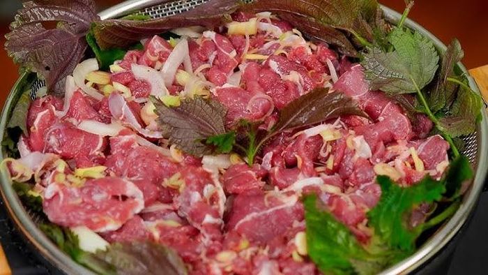 Xếp một lớp sả và gừng xuống đáy đĩa hoặc xửng hấp. Tiếp đó trải một phần lá tía tô lên trên rồi cho thịt bò đã ướp vào. Phủ thêm lá tía tô, hành lá và một ít gừng thái sợi. Ảnh minh họa.