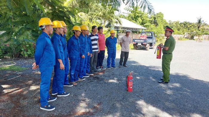 Đội được cán bộ Phòng Cảnh sát PCCC và cứu nạn, cứu hộ hướng dẫn sử dụng bình chữa cháy xách tay. Ảnh: Bộ Công an.