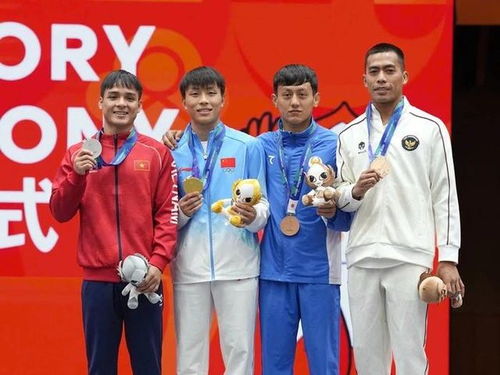 Võ sĩ Tán thủ Đinh Văn Tâm (ngoài cùng bên trái) nhận HCB hạng 56kg. Ảnh: Độc Lập