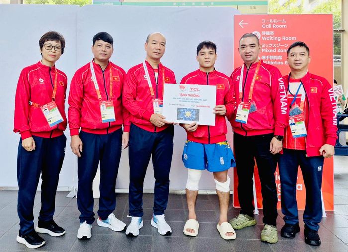 Đinh Văn Tâm nhận thưởng nóng tại ASIAD 20 từ lãnh đạo Đoàn thể thao Việt Nam. Ảnh: Bùi Lượng