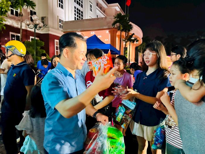 Chủ tịch Ủy ban MTTQ Việt Nam phường Triệu Hải Vân trao quà cho trẻ em. Ảnh: Trần Oanh.