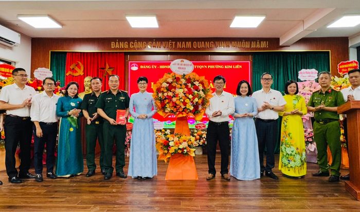 Bí thư Đảng ủy, Chủ tịch HĐND phường Kim Liên Hoàng Thị Phương Ngọc cùng lãnh đạo phường tặng lẵng hoa chúc mừng Ban Chỉ huy Quân sự phường. Ảnh: Nguyên Bảo