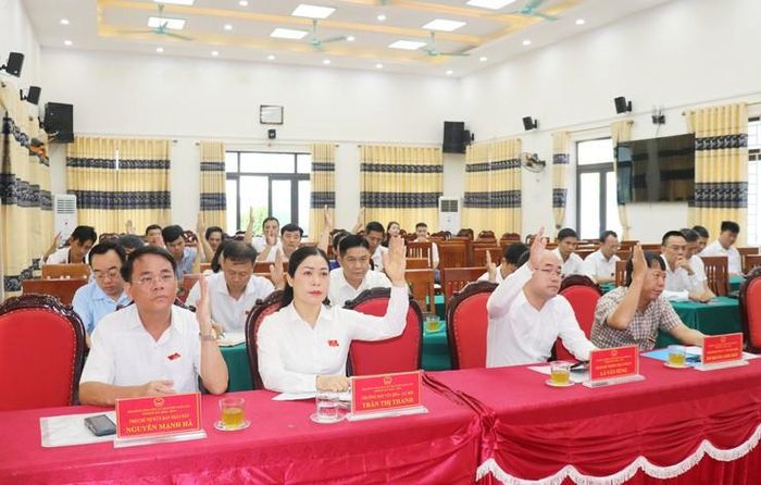 Các đại biểu HĐND xã Trần Phú biểu quyết thông qua Nghị quyết. Ảnh: HĐ