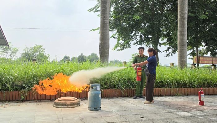 Đại úy Nguyễn Hoàng Anh hướng dẫn người dân kỹ năng sử dụng bình chữa cháy.
