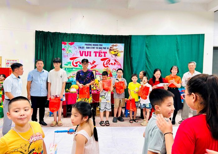Đại diện Tổ dân phố số 18 và thành viên Câu lạc bộ “Từ trái tim đến trái tim” tặng quà Tết Trung thu cho các em thiếu nhi. Ảnh: Trần Oanh.