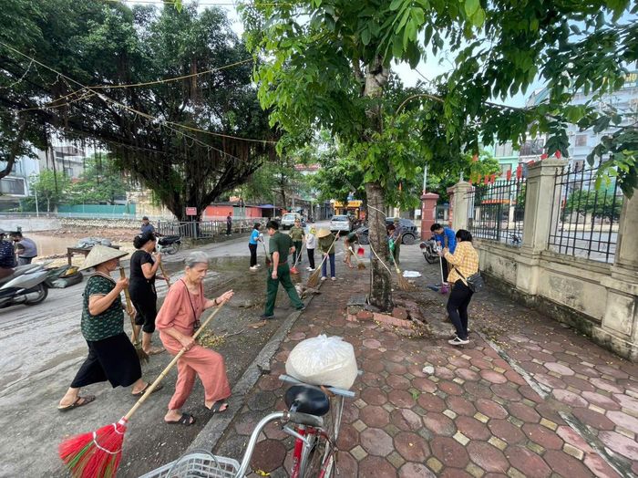 Nhân dân chung tay dọn vệ sinh môi trường khu vực Nhà văn hóa khu dân cư Bằng B (thuộc Tổ dân phố 17, phường Hoàng Liệt). Ảnh: PV