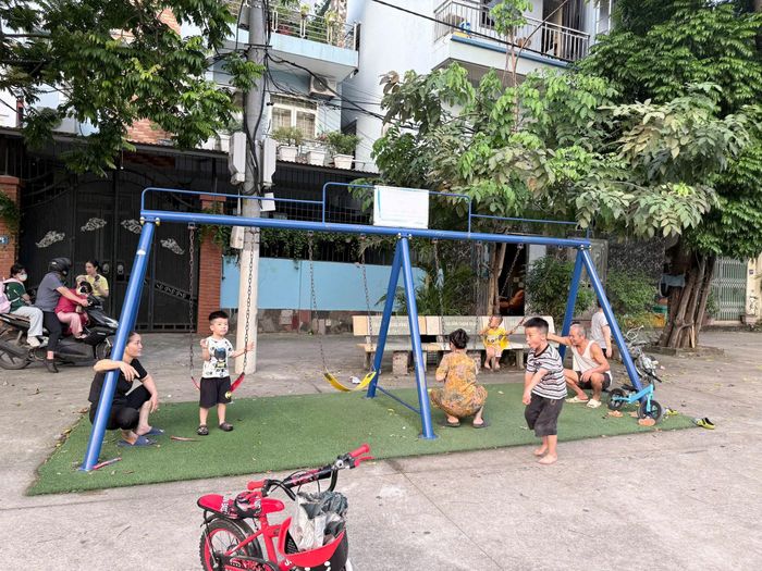 Các cháu thiếu nhi bên xích đu tại sân vui chơi Tổ dân phố 17 Bằng B, phường Hoàng Liệt. Ảnh: PV