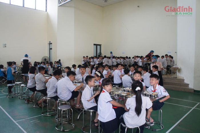 11h00 trưa, khu vực ăn bán trú kín chỗ. Các em học sinh tự giác nhận khay cơm nóng sốt và ngồi vào vị trí đã phân chia theo từng lớp.