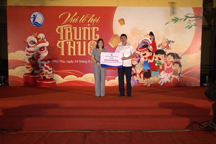 Bà Nguyễn Thị Hiền, Phó giám đốc Quỹ Bảo trợ trẻ em Việt Nam trao biển tượng trưng hỗ trợ cho trẻ em có hoàn cảnh khó khăn tỉnh Phú Thọ. Ảnh: Vương Long.