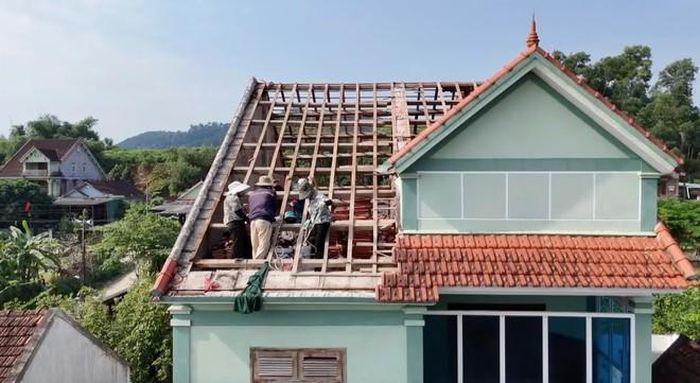 Người dân thu dọn đồ đạc sau khi tháo dỡ nhà, chuẩn bị bàn giao mặt bằng cho dự án mở rộng nghĩa trang. Ảnh: Hữu Minh.