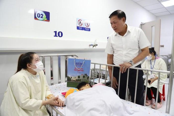 Thứ trưởng Bộ Y tế Đỗ Xuân Tuyên thăm hỏi bệnh nhi. Ảnh: P.Thương