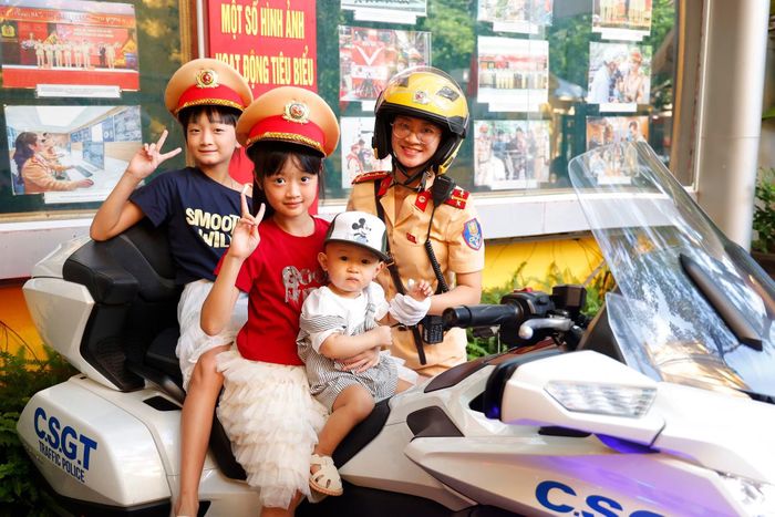 Các cháu hào hứng chụp ảnh kỷ niệm cùng những người đồng nghiệp của bố, mẹ bên chiếc xe dẫn đoàn