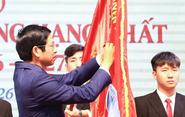 Thừa ủy quyền của Chủ tịch nước, Thứ trưởng Bộ VHTTDL Hồ An Phong gắn Huân chương Lao động hạng Nhất lên cờ truyền thống của nhà trường
