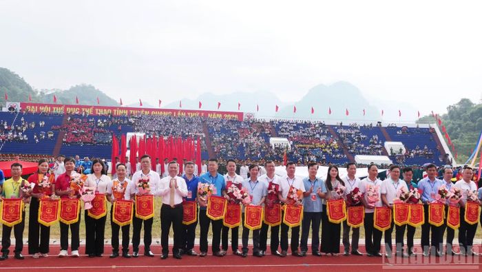 Các đồng chí lãnh đạo tỉnh Tuyên Quang trao cờ lưu niệm cho các đoàn tham dự đại hội. (Ảnh: KHÁNH TOÀN)