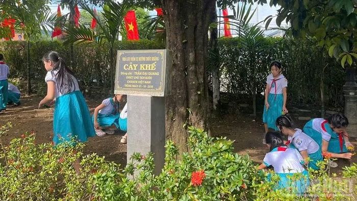 Các em thanh thiếu nhi dọn vệ sinh khuôn viên Nhà lưu niệm cụ Huỳnh Thúc Kháng. (Ảnh: TB)
