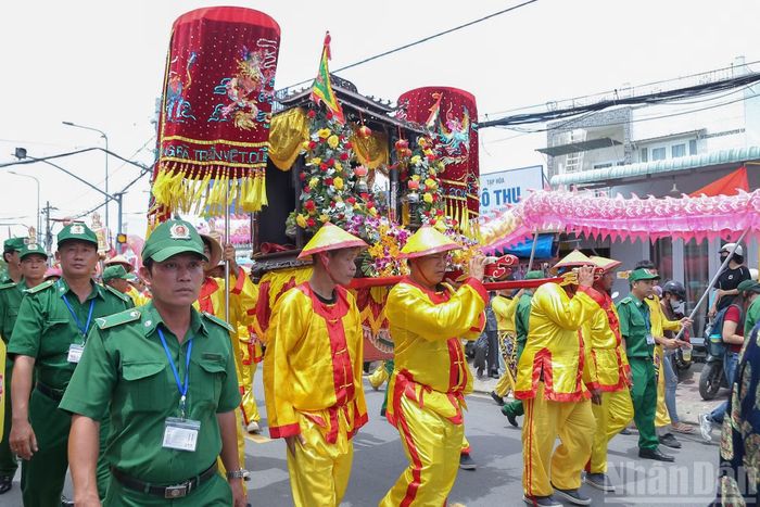 Kiệu Ông được các phu lính khênh trên vai đi từ ghe lên Bến đò Cơ Khí, giữa dòng người dân.