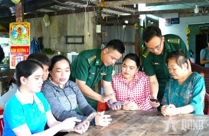Cán bộ Đồn Biên phòng Đất Mũi phối hợp với chính quyền địa phương trao đổi thông tin, nắm tình hình.