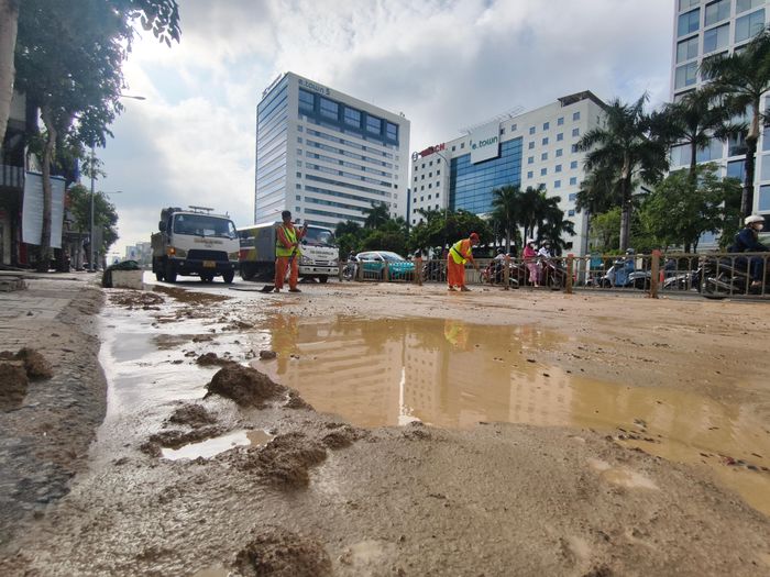 Lực lượng chức năng dọn dẹp bùn đất trên đường Cộng Hòa, sáng 22-9. Ảnh: NGUYỄN TÂN