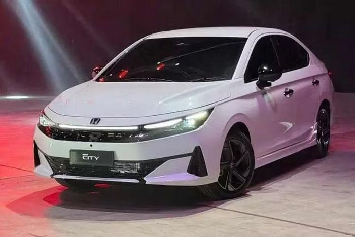Honda City 2026 được trang bị đầu xe mới với thiết kế sắc sảo hơn, đi kèm cụm đèn pha mảnh hơn và cản trước cải tiến. Thiết kế phần dưới của cản trước sẽ thay đổi theo phiên bản. Các bản thấp sẽ sở hữu hốc hút gió có thiết kế hướng xuống và ít góc cạnh hơn. Hai bên được bao quanh bởi các khe thoát gió dạng rèm sơn màu đen. Trong khi đó, các bản RS được trang bị hốc hút gió trung tâm với thiết kế hất lên sắc nét hơn.