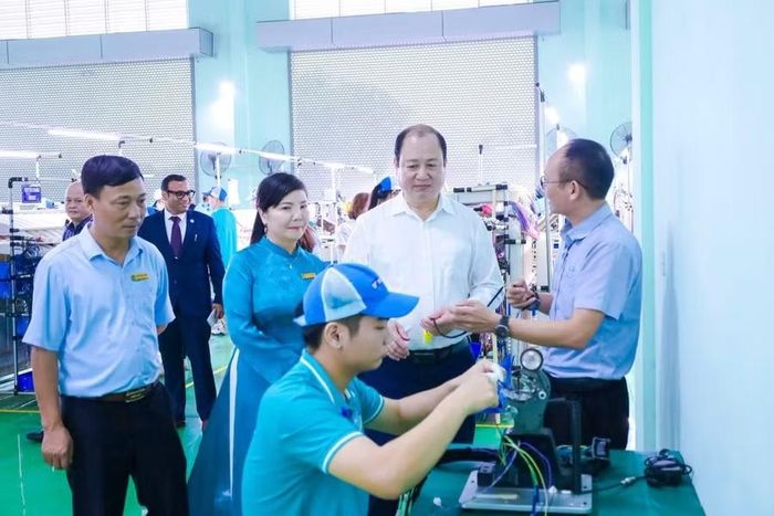 Ông Hoàng Long Biên (áo trắng) tham quan xưởng thực hành tại Trường CĐ Cơ khí nông nghiệp.