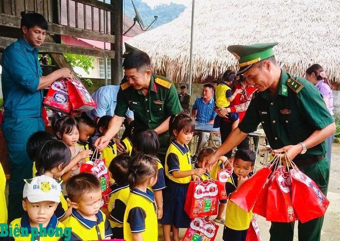 Cán bộ Đồn Biên phòng Bát Mọt và các lực lượng tặng quà cho thiếu niên, nhi đồng trên địa bàn. Ảnh: TK