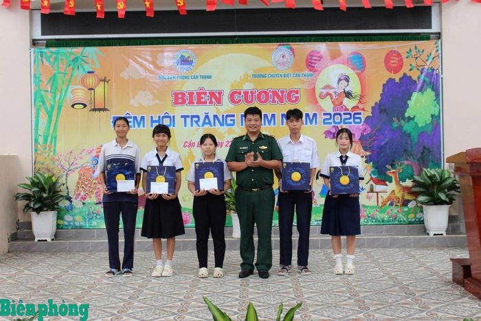 Thiếu tá Trịnh Hữu Hùng, Đồn trưởng Đồn Biên phòng Cần Thạnh trao quà và học bổng cho 5 cháu học sinh trong Chương trình “Nâng bước em tới trường-Con nuôi đồn Biên phòng”. Ảnh: Quang Tiến