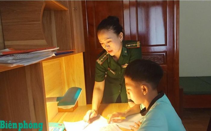 Cán bộ Đồn Biên phòng Nậm Càn hướng dẫn các con nuôi học tập tại đơn vị. Ảnh: Hải Thượng