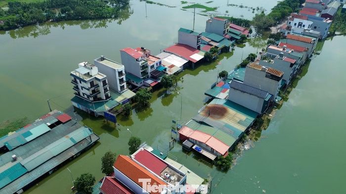 Khu dân cư ngay sát khu vực này cũng bị nước bao quanh. Một số đường dân sinh dẫn vào nhà dân ngập sâu, người dân phải tìm lối khác để đi lại.