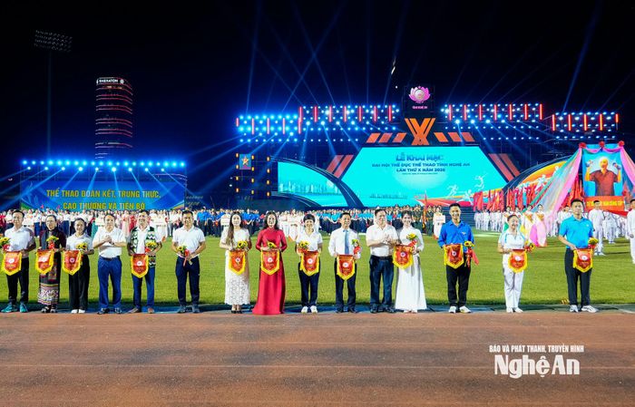 Các đồng chí lãnh đạo, Ban Tổ chức trao cờ lưu niệm và hoa cho các đoàn vận động viên và các lực lượng về tham gia Đại hội TDTT tỉnh Nghệ An lần thứ X năm 2026. Ảnh: Phạm Bằng