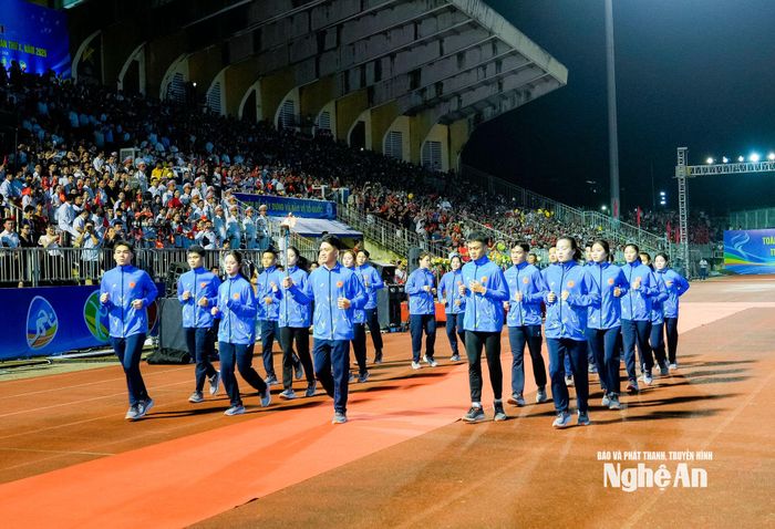 Ngọn đuốc truyền thống của đại hội đang được vận động viên Nguyễn Trọng Dũng cùng 20 VĐV xuất sắc của tỉnh nhà trang trọng rước vào lễ đài. Ảnh: Phạm Bằng