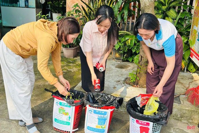 Chị Trần Thị Trường (áo vàng) ở thôn Minh Hải, xã Thạch Khê được HTX Môi trường Thạch Khê hướng dẫn phân loại rác tại nhà.