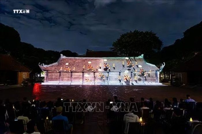 Màn trình chiếu công nghệ 3D Mapping hiện đại trên kiến trúc cổ kính của Văn Miếu tái hiện hành trình đạo học Việt Nam trước đông đảo khán giả. Công nghệ chiếu sáng nghệ thuật thực cảnh đã biến các di tích lịch sử thành những "sân khấu đêm" sống động, tạo nên sản phẩm du lịch đêm đặc sắc giữ chân du khách. Ảnh: Tiến Long/TTXVN phát
