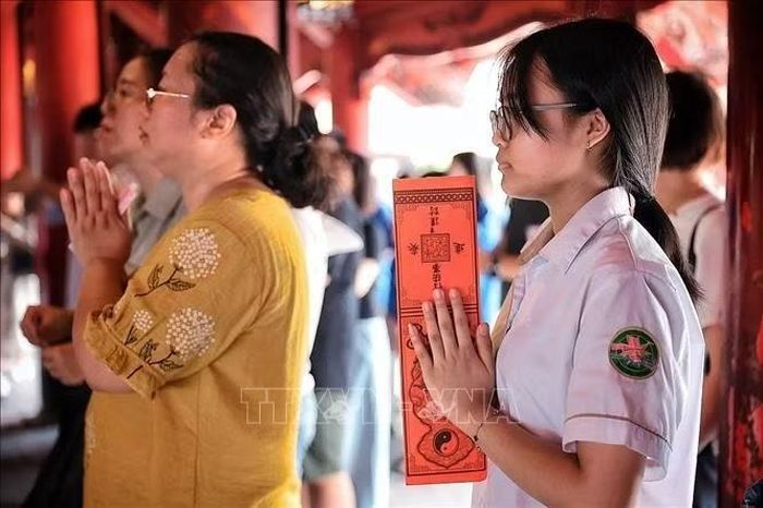Nữ sinh thành kính cầu may trước kỳ thi quan trọng. Phạm Tuấn Anh/TTXVN