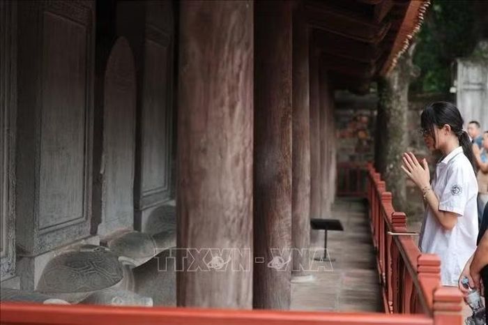 Nữ sinh thành kính trước khu bia Tiến sĩ, gửi gắm mong muốn học hành thuận lợi, thi cử suôn sẻ. Ảnh: Phạm Tuấn Anh/TTXVN