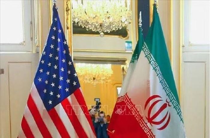 Quốc kỳ Mỹ (trái) và Iran tại một bàn đàm phán. Ảnh: MNA/TTXVN
