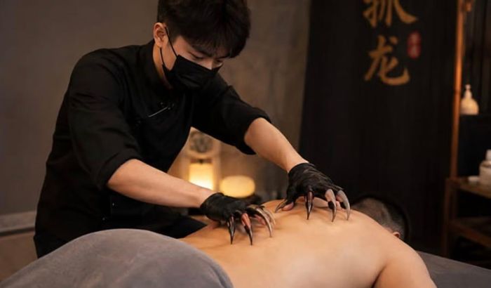 Khách hàng nằm thư giãn trong khi nhân viên sử dụng móng tay giả bằng nhựa để nhẹ nhàng gãi lên cơ thể, giúp giải tỏa căng thẳng và thư giãn. Ảnh chụp màn hình: Mạng xã hội