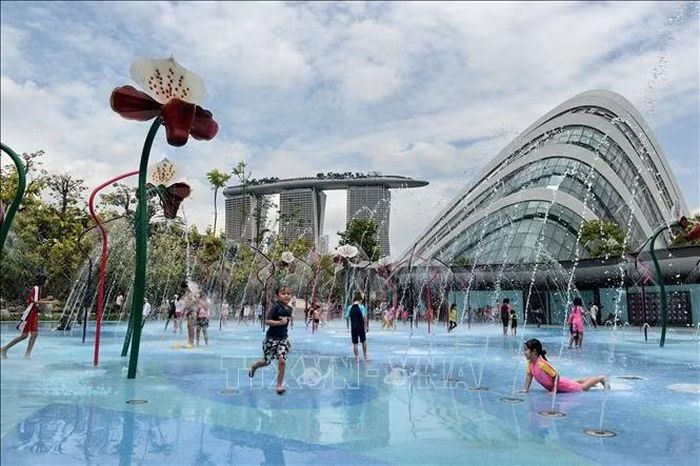 Trẻ em chơi đùa bên vòi phun nước tại Singapore. Ảnh: AFP/TTXVN