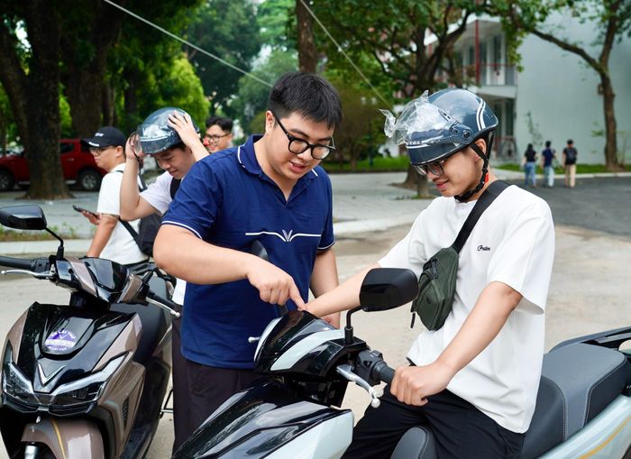 Nhân viên kỹ thuật hãng xe VinFast nhiệt tình hướng dẫn sinh viên tham gia lái thử xe máy điện (Ảnh: Đặng Ngân).