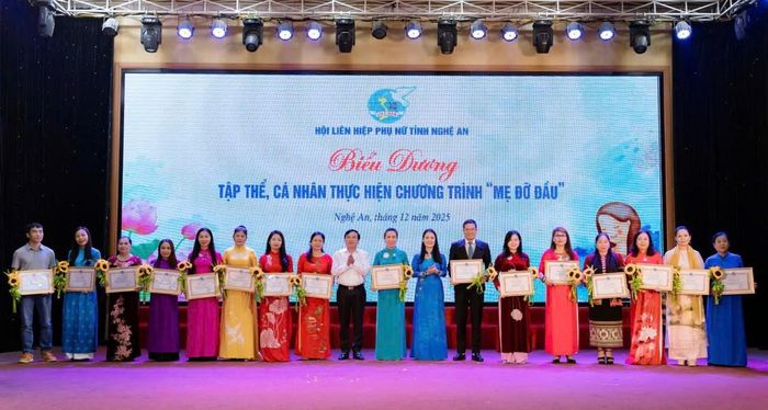 Phó Chủ tịch Hội LHPN tỉnh Nghệ An Nguyễn Thị Hà (thứ 8 từ phải qua) biểu dương các tập thể, cá nhân thực hiện chương trình "Mẹ đỡ đầu" tại tỉnh Nghệ An