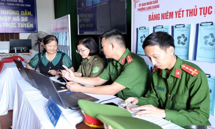  Cán bộ Công an phường Lạng Giang hỗ trợ người dân cài đặt chữ ký số. 