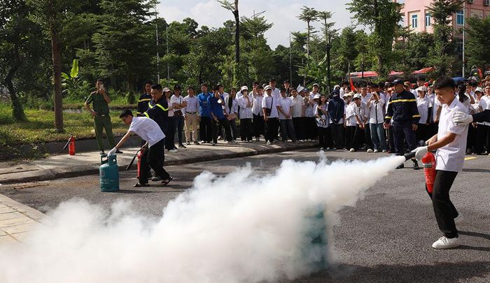 Học sinh Trường Trung học phổ thông Giáp Hải thực hành chữa cháy bằng bình chữa cháy.