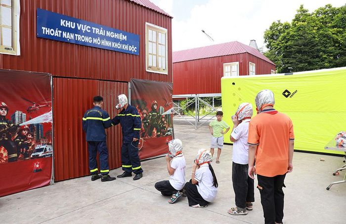 Học sinh tham gia chương trình trải nghiệm thoát nạn trong mô hình khói khí độc.