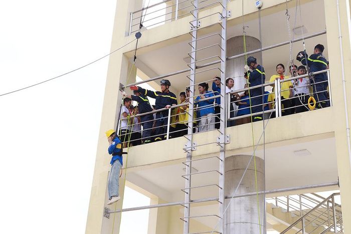 Học sinh, người dân trải nghiệm thoát nạn từ tầng cao bằng thang hạ chậm.