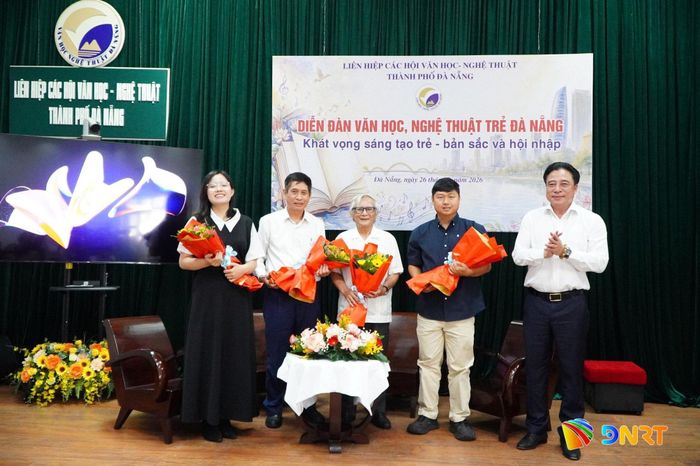 Phó Bí thư Thường trực Thành ủy Nguyễn Khắc Toàn (ngoài cùng bên phải) tặng hoa các văn nghệ sĩ chia sẻ tại diễn đàn. Ảnh: TÂM ĐAN