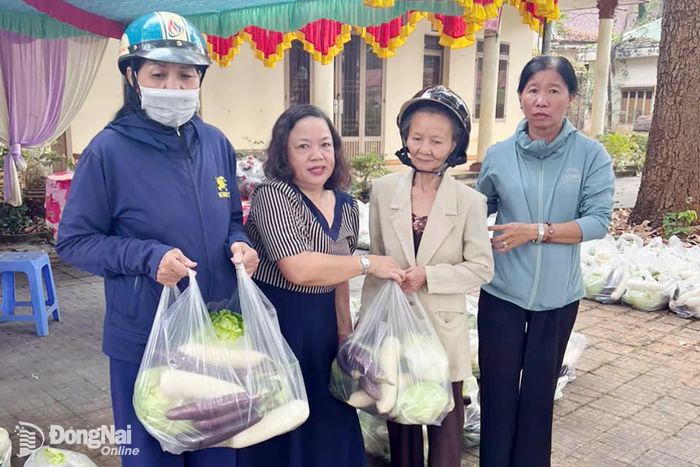 Bà Nguyễn Thị Hương (thứ 2, từ trái qua), Chủ nhiệm Câu lạc bộ Gia đình người khuyết tật Phước Long trao quà Tết năm 2026 cho các hội viên.