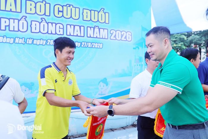 Ban tổ chức trao cờ lưu niệm cho các đơn vị tham dự giải. Ảnh: Huy Anh