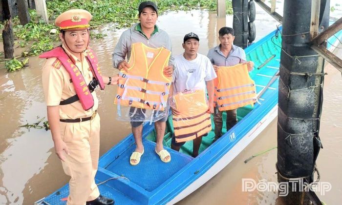 Lực lượng Cảnh sát giao thông thủy trao áo phao cho người dân có phương tiện thủy.